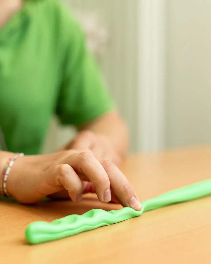 Finger rollen Therapieknete zu einem Strang